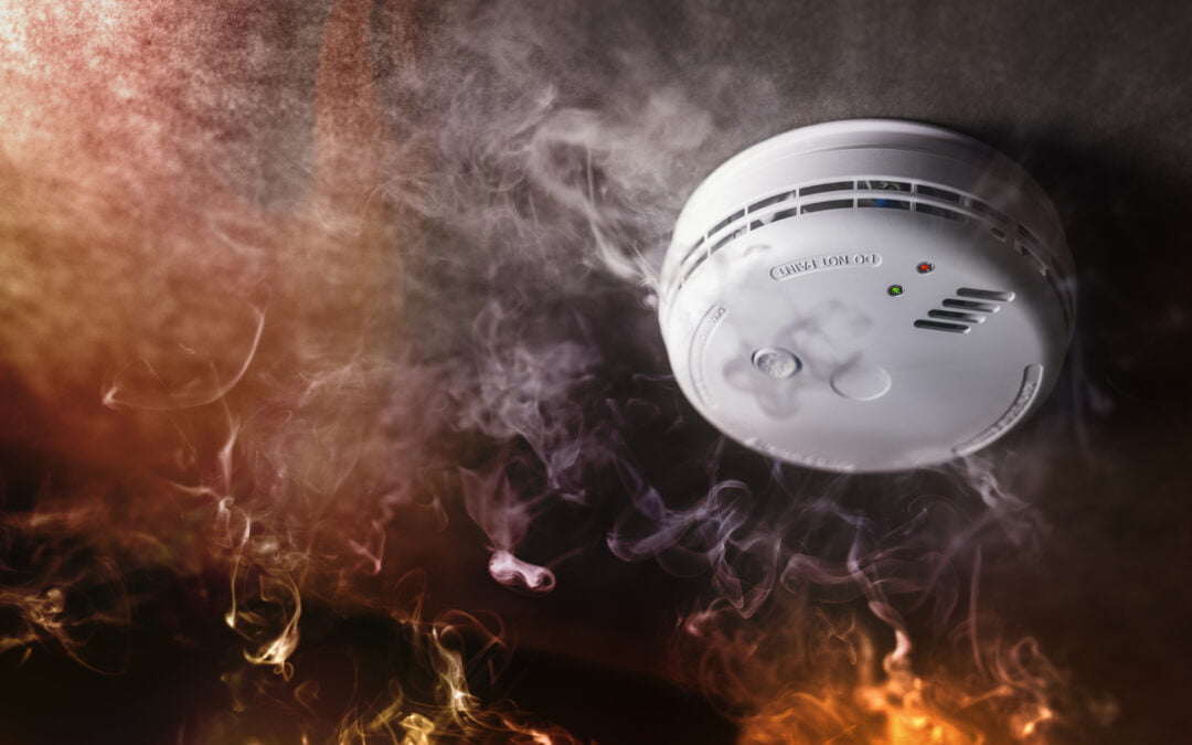 Smoke detector and fire alarm in action background with copy space - fires and home insurance