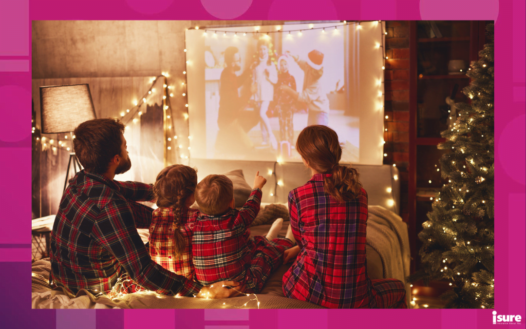holiday movies and insurance - happy family in checkered pajamas: mother father and children watching projector, film, movies with popcorn in christmas holiday evening at home