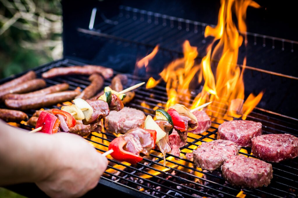 bbq safety tips - Detail Of Beef Burgers and sausages Cooking On A Barbecue