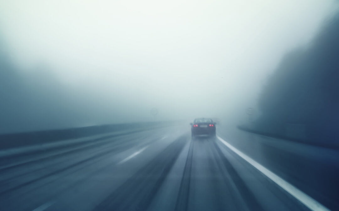 foggy road photo of a car up ahead - driving safely in fog