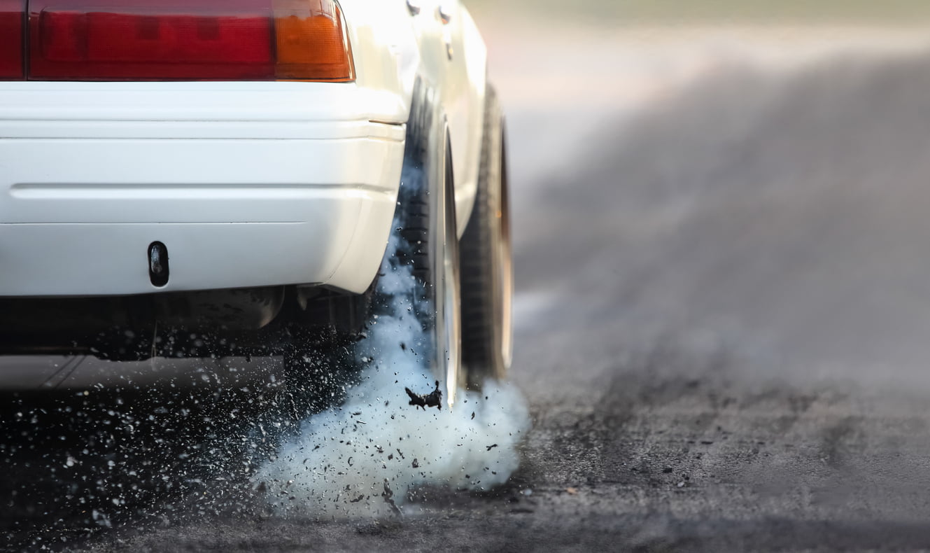 Drag racing car burns rubber off its tires in preparation for the race - stunt driving in Ontario