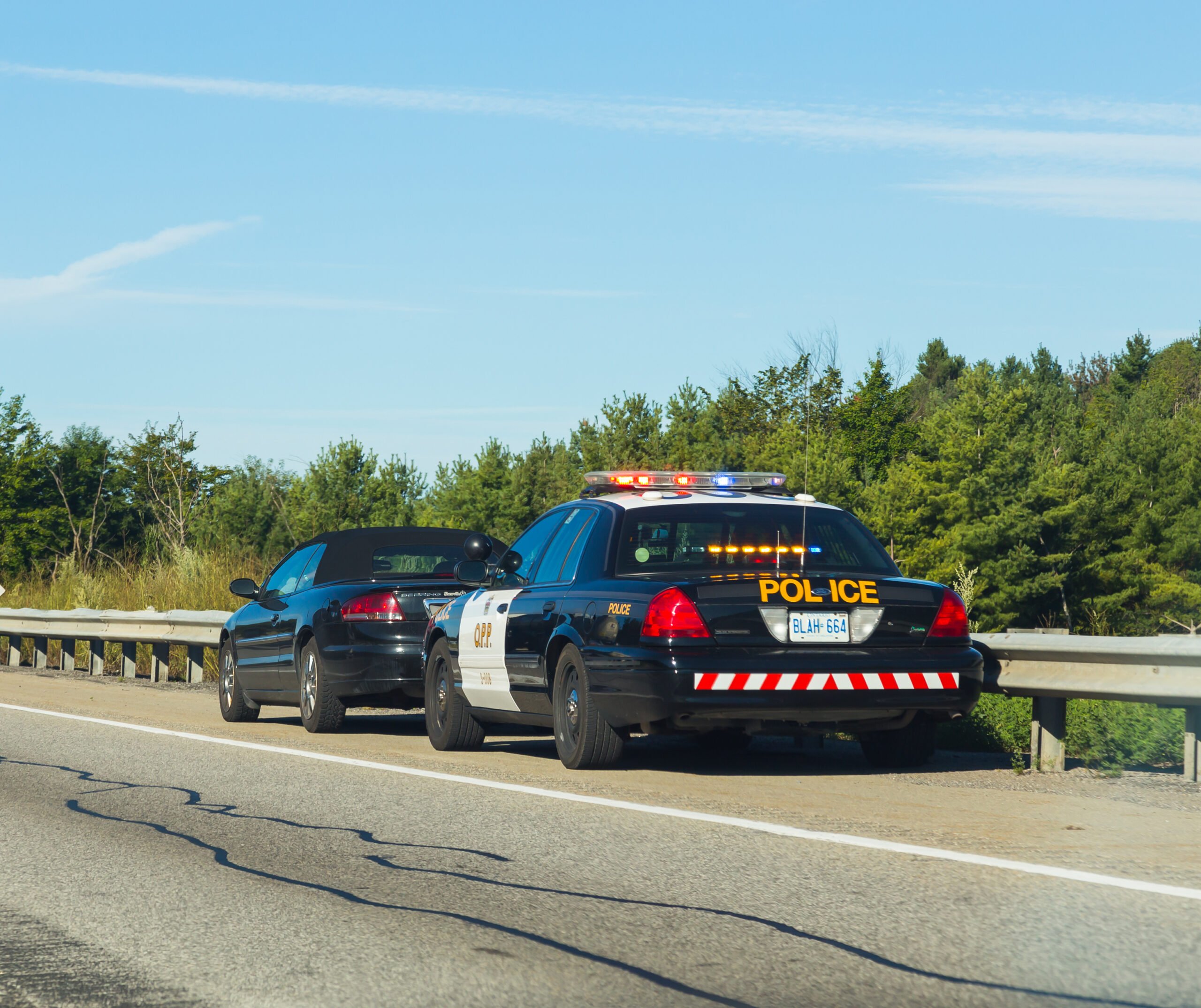 OPP car pulled over to the side of the road with a driver in their vehicle parked in front - driving record of 9