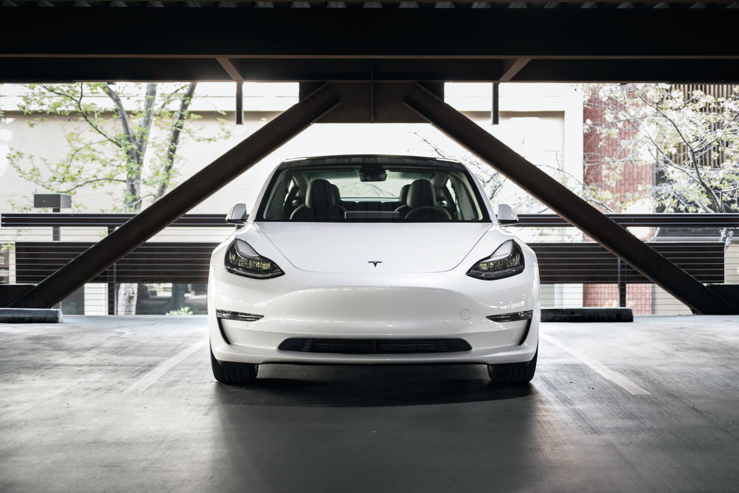 White Tesla car inside a parking garage - best 2022 electric vehicle brands