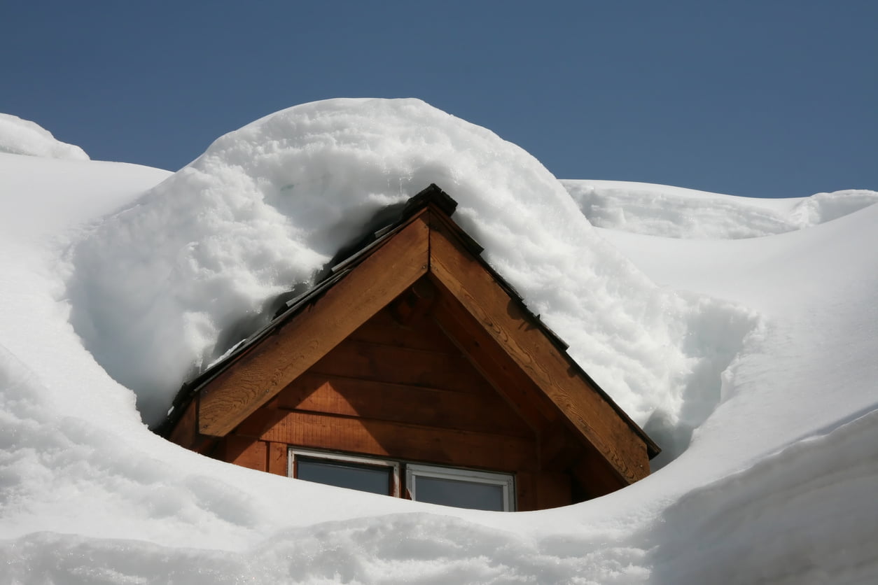 brown house covered in heavy snow - protect your home from snow damage