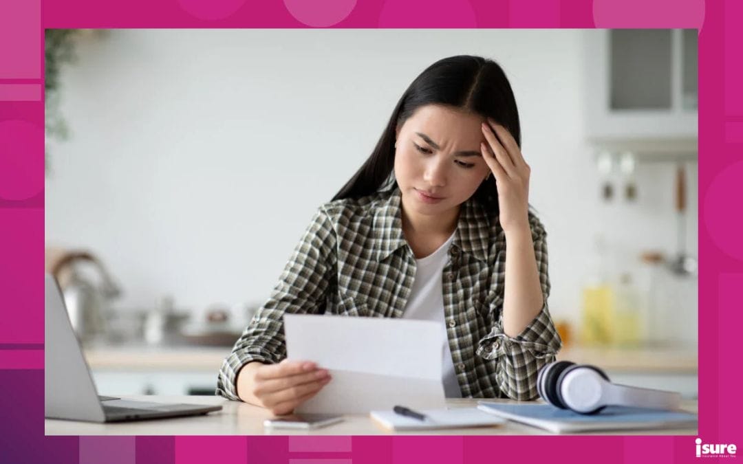 Can your insurer cancel your policy? Upset young asian woman sitting at table with modern laptop in kitchen, reading letter and touching her forehead, copy space. Sad lady holding document or bills, got bad news, home interior