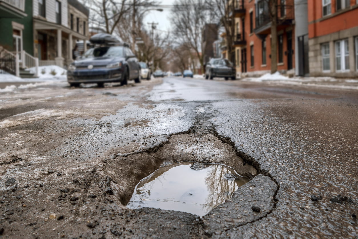 Large deep pothole in Montreal street, Canada - pothole season