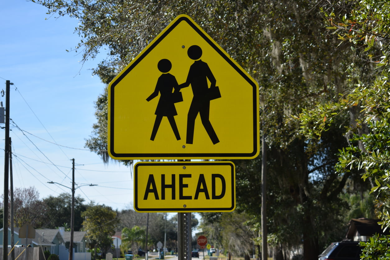 A sign symbolizes a school crossing zone. school zone signs and speed limits in Ontario