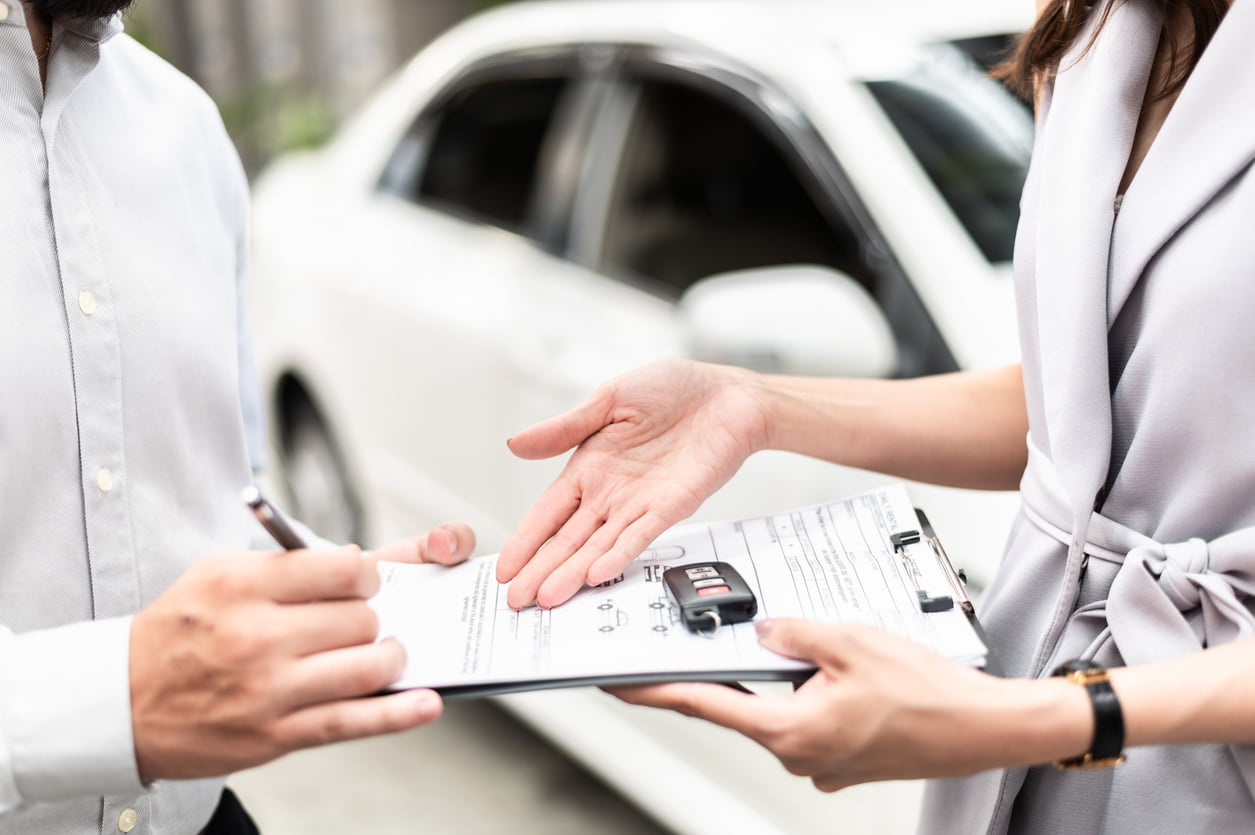 lease takeover - Automotive business, car sale or rental concept : Happy customer with car dealer agent making deal and signing on agreement document contract in auto showroom or car dealer office.