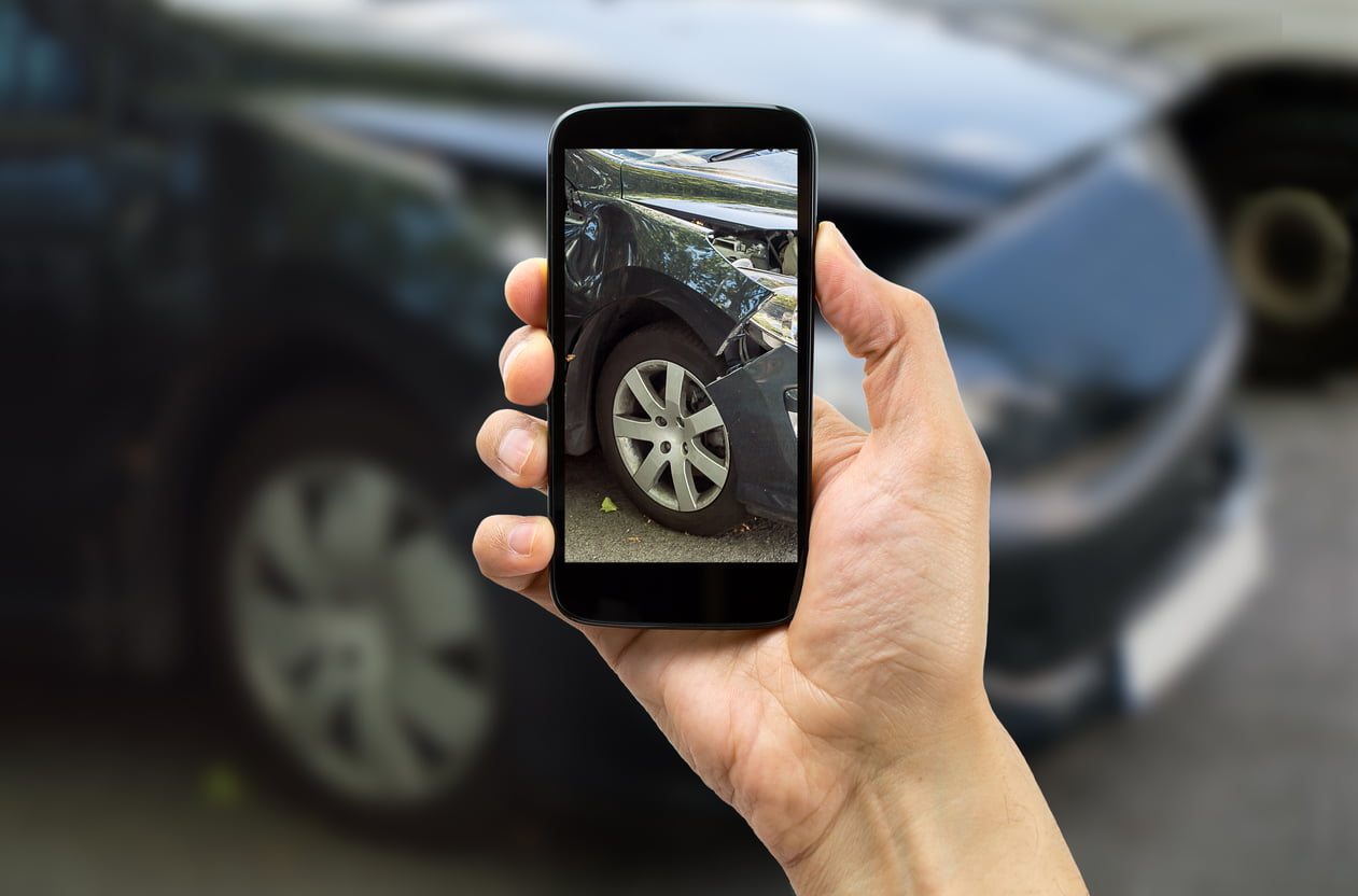 collision coverage in Ontario - Man photographing his vehicle damages for accident insurance