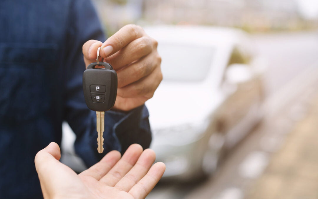 primary and secondary drivers - Car key, businessman handing over gives the car key to the other woman on car background.