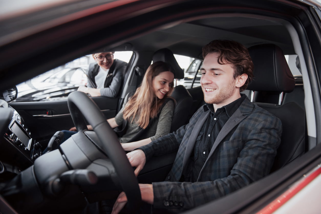 buying a used vehicle - Happy beautiful couple is choosing a new car at dealership.
