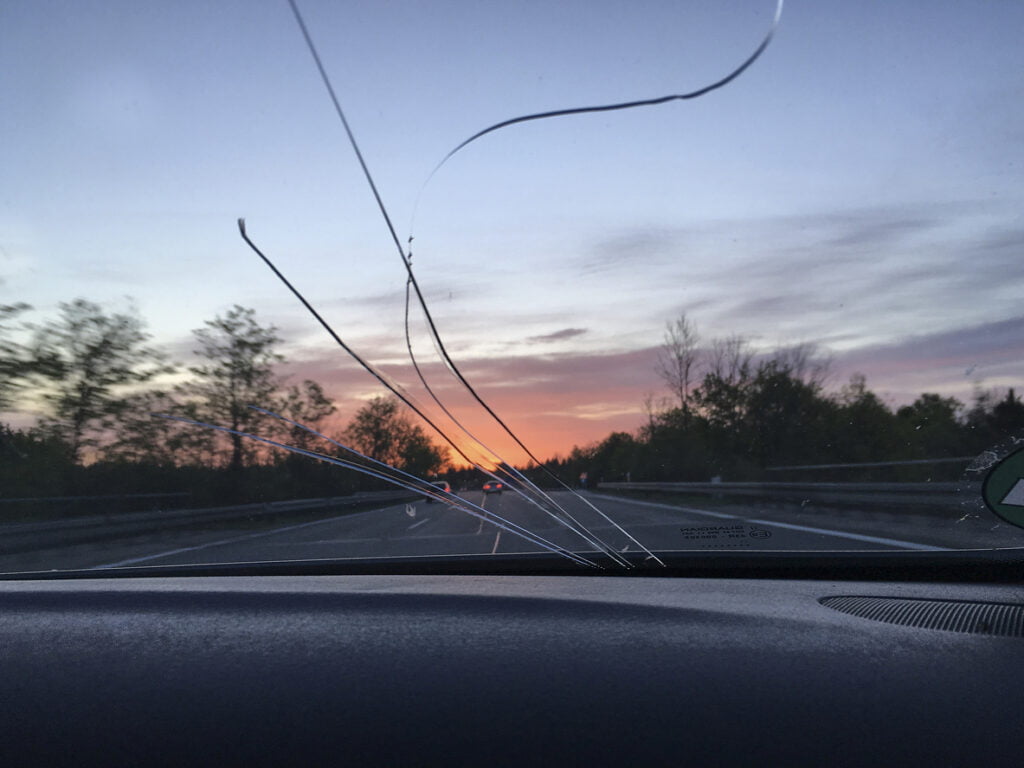 cracked windshield with a background view of a sunset