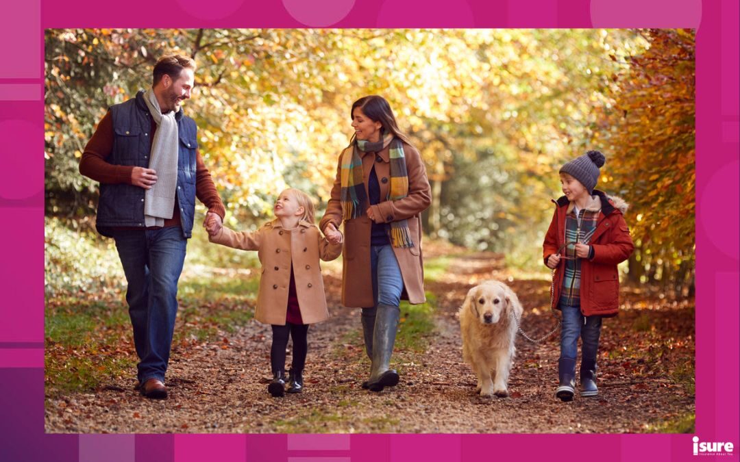 family-friendly fall activities - Family With Pet Golden Retriever Dog Walking Along Track In Autumn Countryside Holding Hands