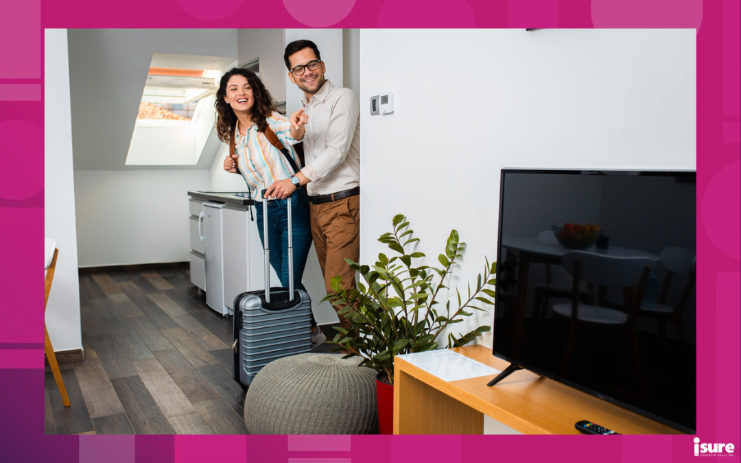 what is home sharing - Smiling couple with suitcase arriving in apartment.