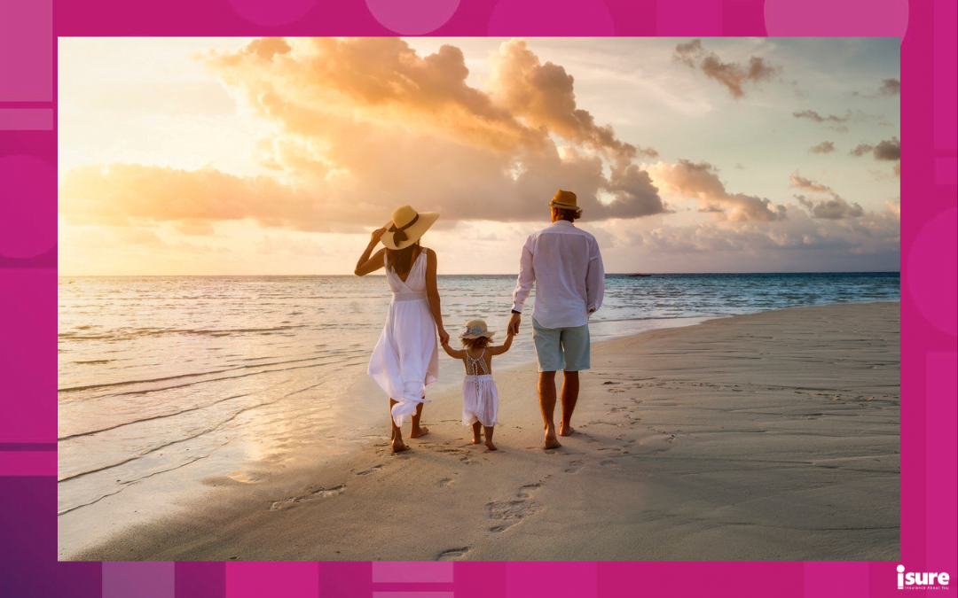 travel tips for new snowbirds - A elegant family in white summer clothing walks hand in hand down a tropical paradise beach during sunset tme and enjoys their vacation time