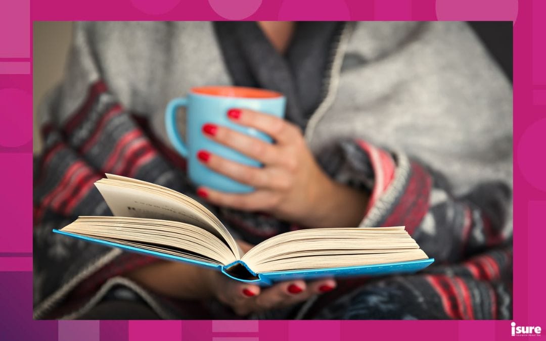 Woman with blanket and mug having a cozy read in the fall