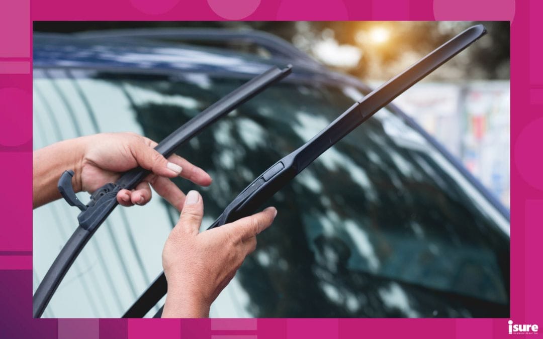 A man adjusts his windshield wipers on his vehicle.