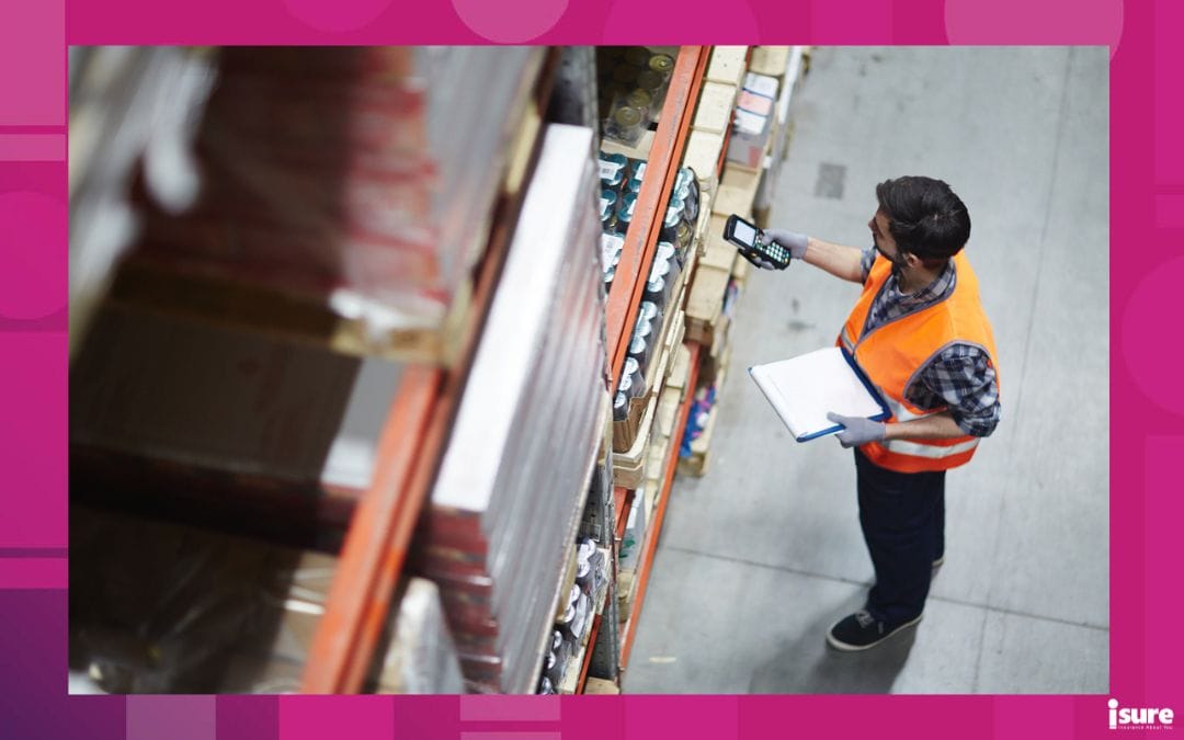WSIB - An employee in an orange reflective jacket working in a stock room.