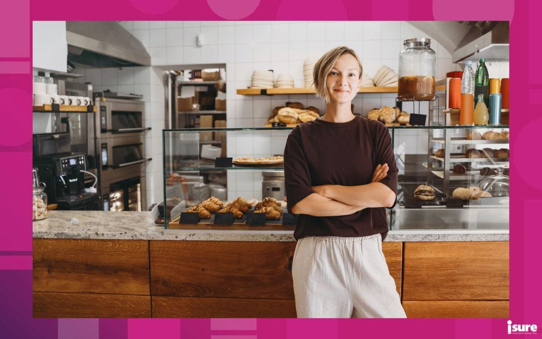 starting a small business - Portrait of smiling young woman entrepreneur standing at the counter of her bakery and coffee shop. Local small business owner indoors. Female in cafe near showcase with fresh croissants and bread.