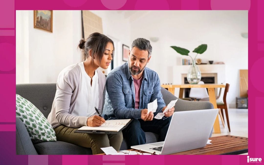 Mature couple calculating bills at home using laptop and calculator. Multiethnic couple working on computer while calculating finances sitting on couch. Mature indian man with african american woman at home analyzing their finance with documents and looking over factors affecting home insurance premiums