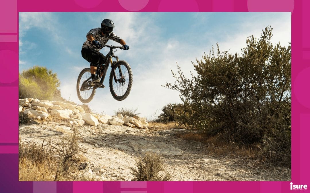 Professional bike rider jumping during downhill ride on a mountain bike trail