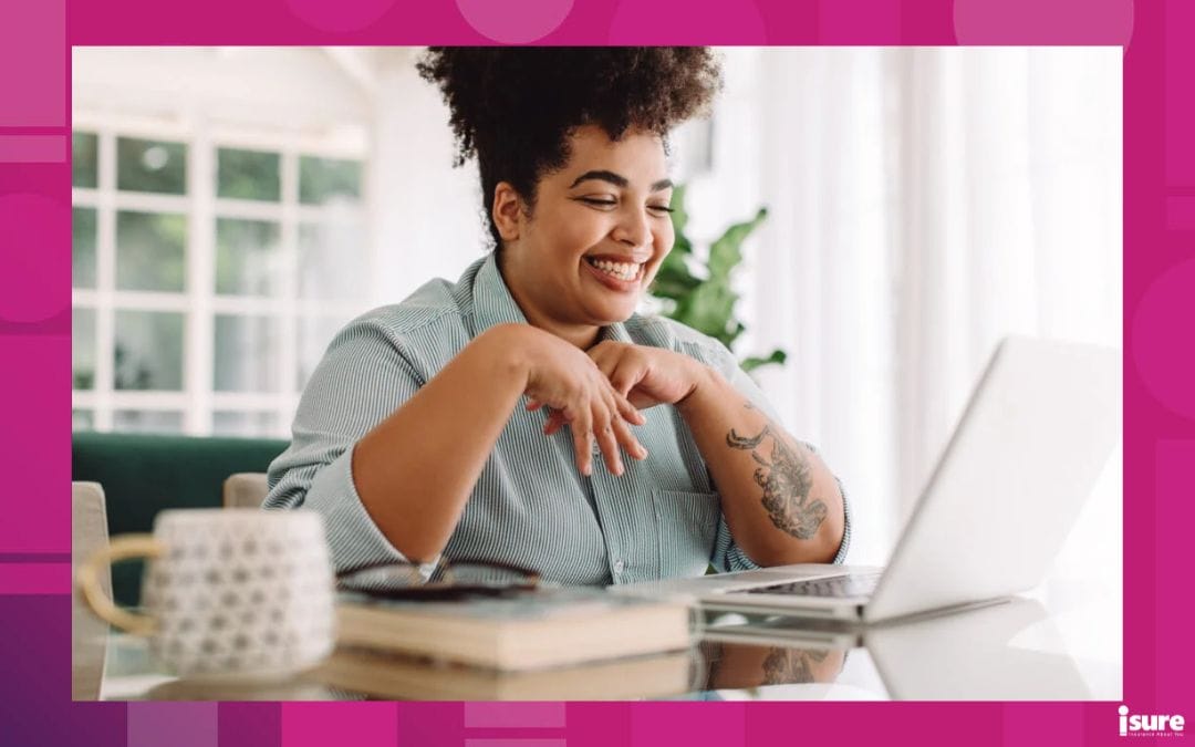 woman inside her home smiling at her computer with a mug beside it, learning about what home insurance is