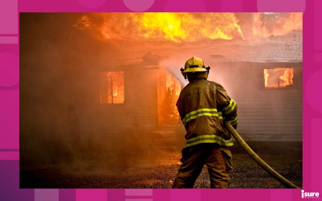 Firefighter spraying water at a house fire that will result in a home total loss