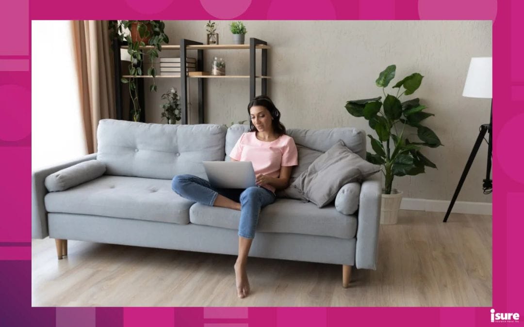 young woman sitting on her couch with a laptop on her lap, looking up the myths about tenant insurance