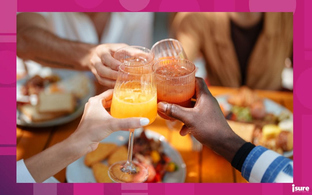 Close-up of diverse friends' hands toasting with fresh juice over a nutritious brunch spot in Toronto, featuring vibrant meals and glassware. Celebration of friendship and healthy living in a warm, inviting atmosphere.