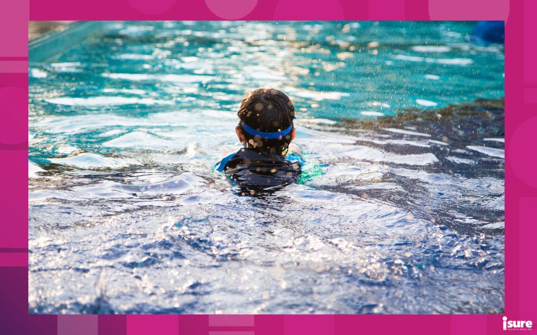 A boy learning to swim in a large pool, showing the importance of water safety