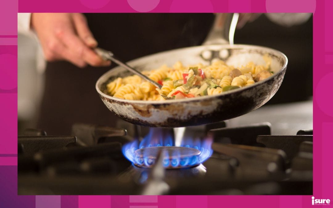 cook preparing pasta dish with vegetables on stove using natural gas