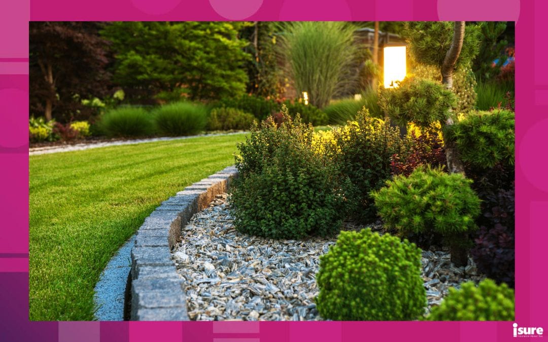 Closeup of Professional Landscaping Flower Bed with Decorative Green Garden Plants and Evenly Mowed Lawn in the Background.