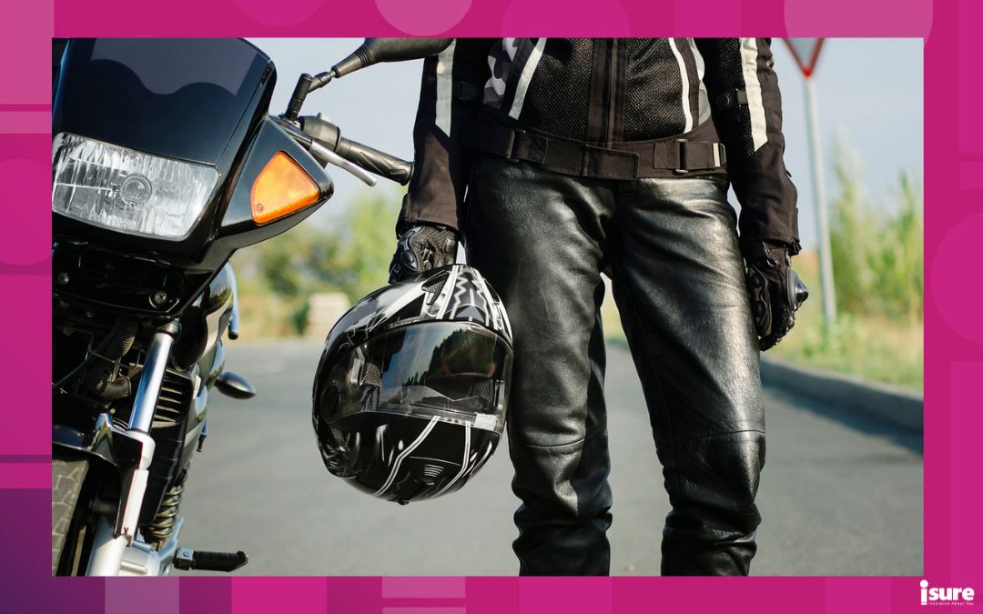 motorcycle coverage - A woman biker holds a protective helmet in her hand, standing next to a motorcycle. Close-up