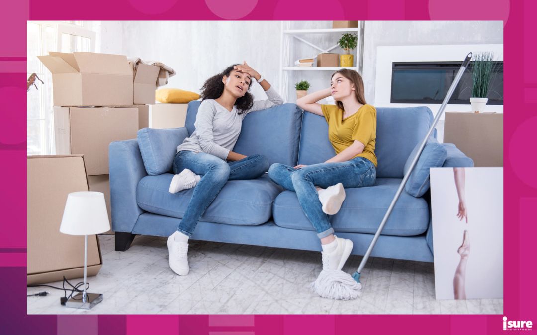 Feeling fatigue. Charming young girls sitting on the sofa and wiping sweat off their foreheads, being tired after cleaning a new rent-controlled apartment