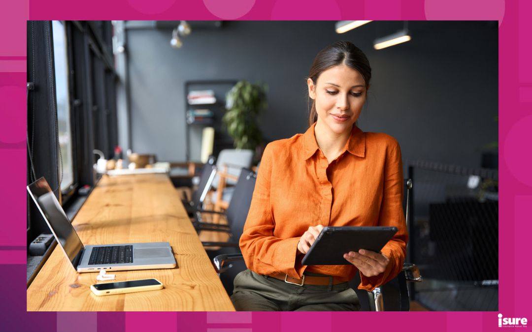 Businesswoman uses a tablet in an office, representing Canaada's softening commercial insurance market.