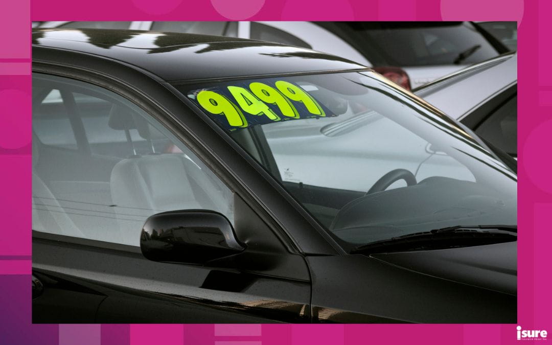 Used car with a visible price tag at a dealership, representing negotiations and pricing strategies in the Canadian used car market.