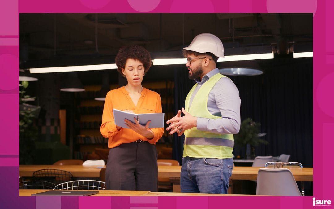Workers discussing WSIB coverage requirements in Ontario, while standing in their workplace with safety work clothing visible to reflect regulated job conditions.