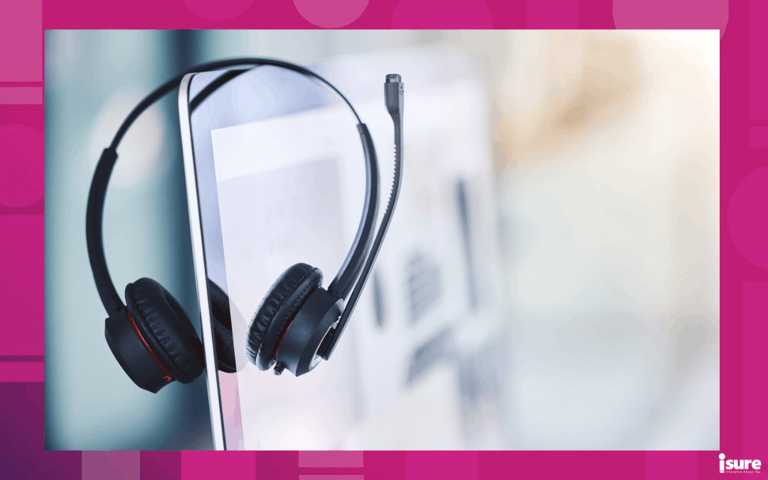 A headset hanging on a computer for someone working in the insurance industry.